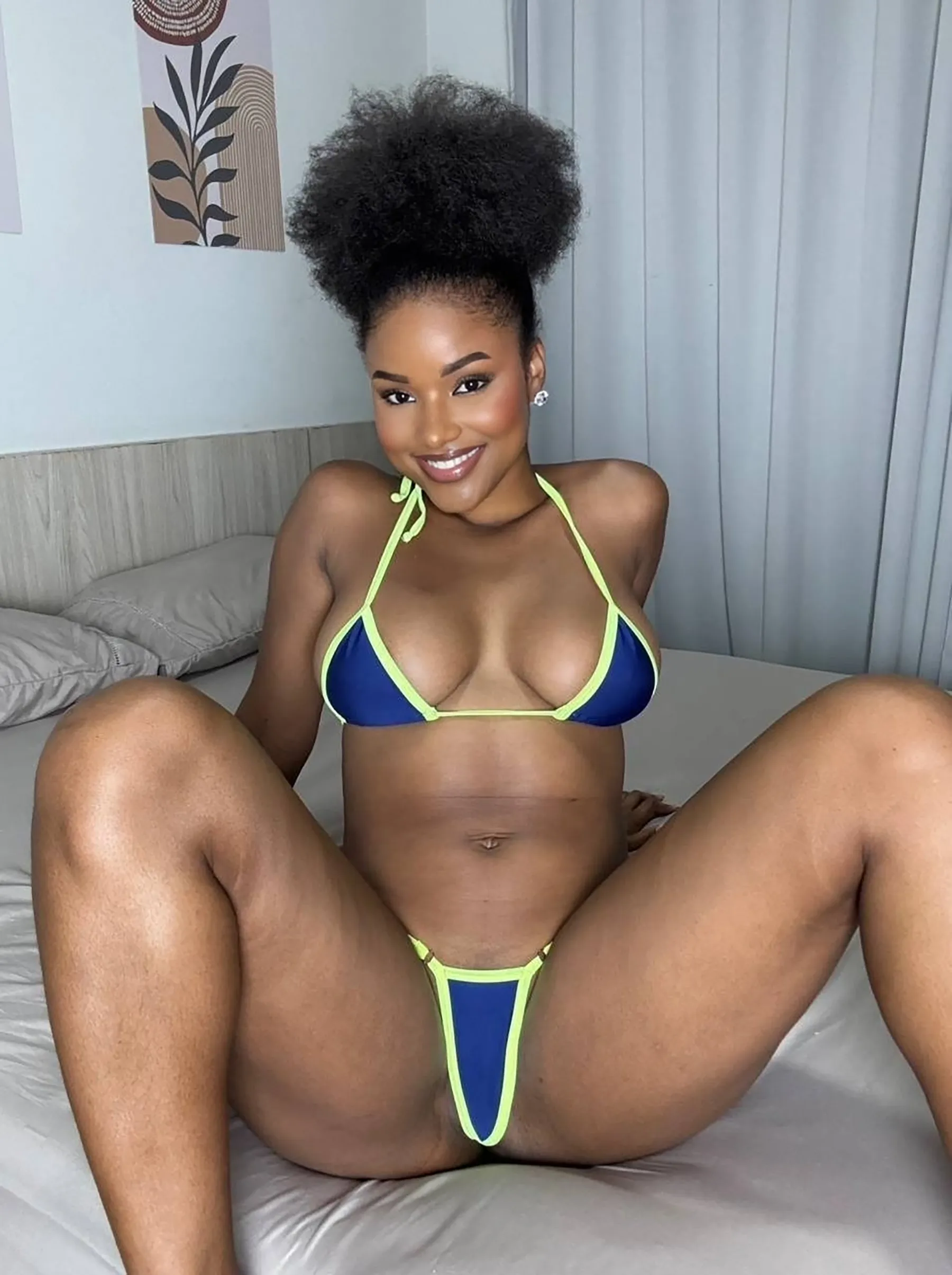 A black woman poses confidently in a blue bikini and black panties, showcasing her style as an ebony OnlyFans model.